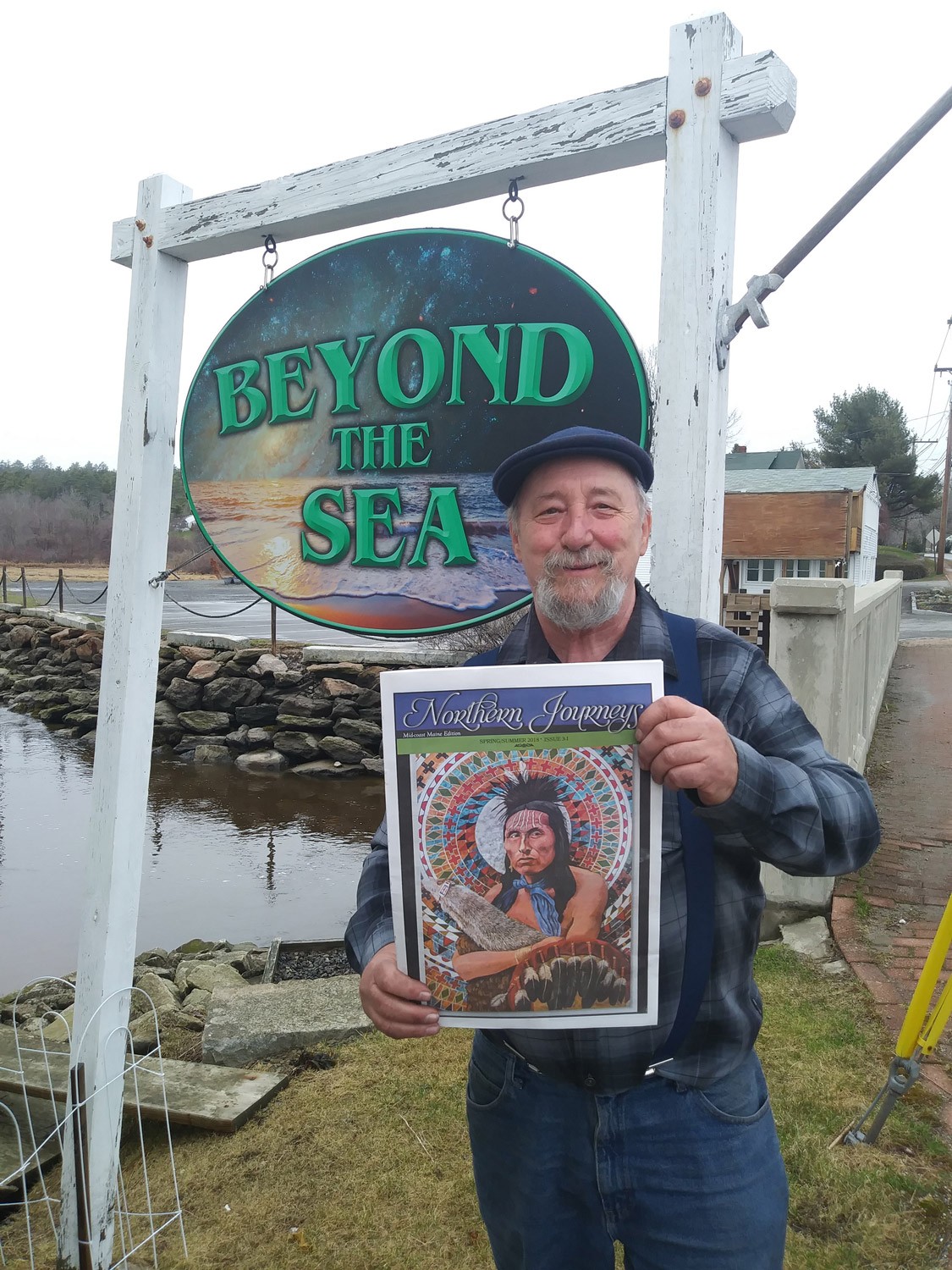 A picture ofJason Thomas holding a Maine's edition of Northern Journey's Magazine.