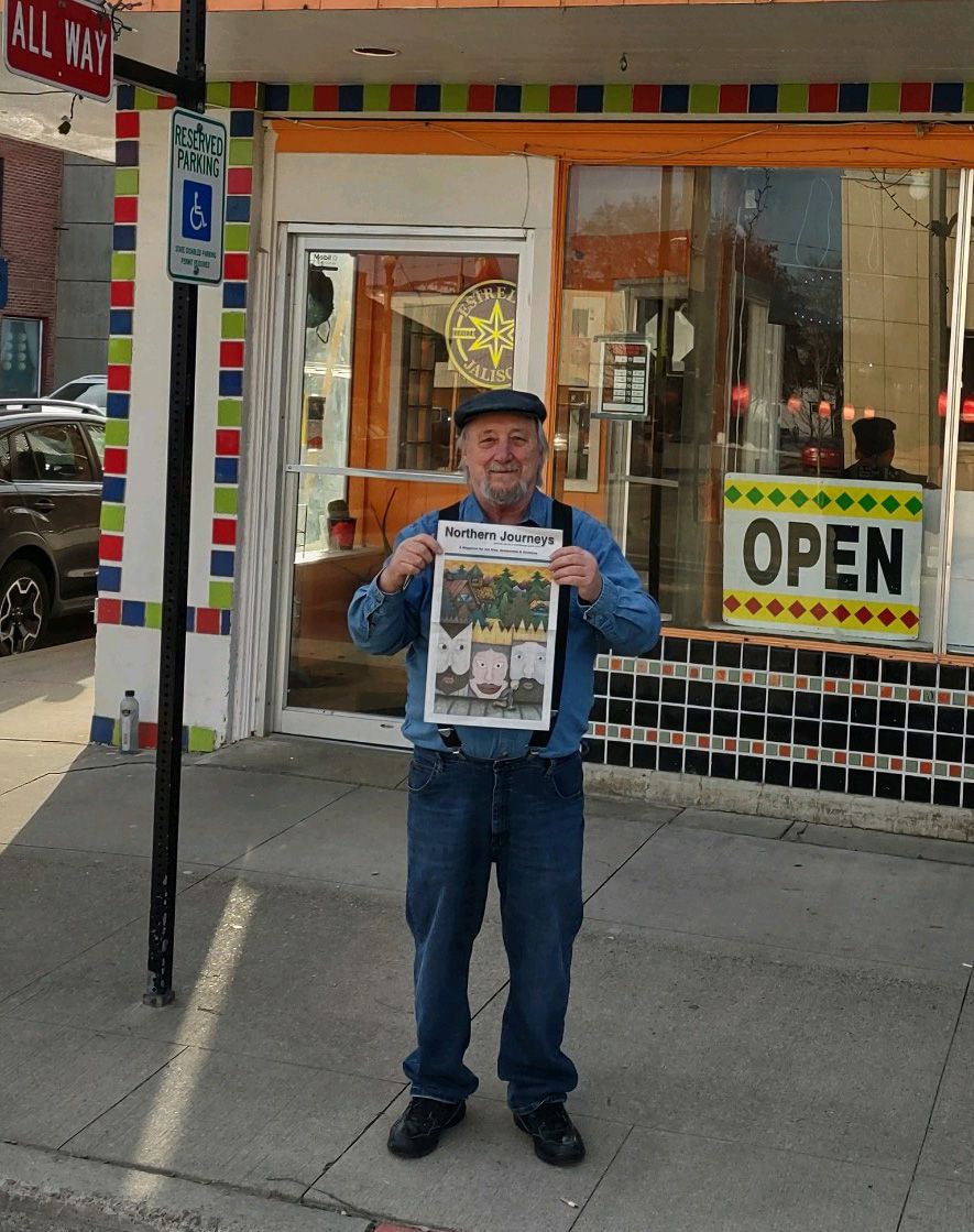 A picture ofJason Thomas holding a Northern Journeys Magazine published for the Pacific Northwest.